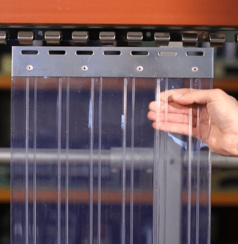 Workers installing PVC strip curtains for industrial use