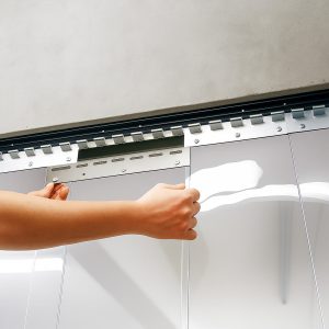 Worker hangs PVC curtains