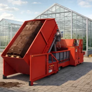 Bale breaker and buffer hopper installed outside a modern industrial greenhouse with a compressed substrate bale inside the machine.